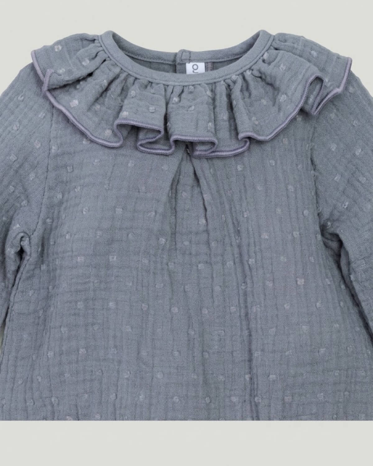 Close-up detail of frilled ruffle collar and textured plumeti double gauze cotton on slate grey-blue Spanish baby romper.