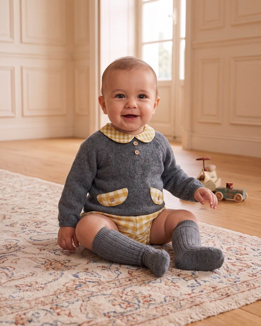 Baby wearing traditional Spanish grey knitted jumper with yellow gingham Peter Pan collar, faux pockets and matching knee socks.