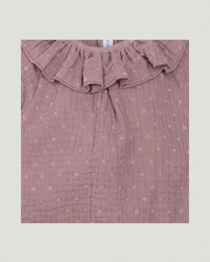 Close-up detail of frilled ruffle collar and textured plumeti double gauze cotton on dusty pink Spanish baby romper.