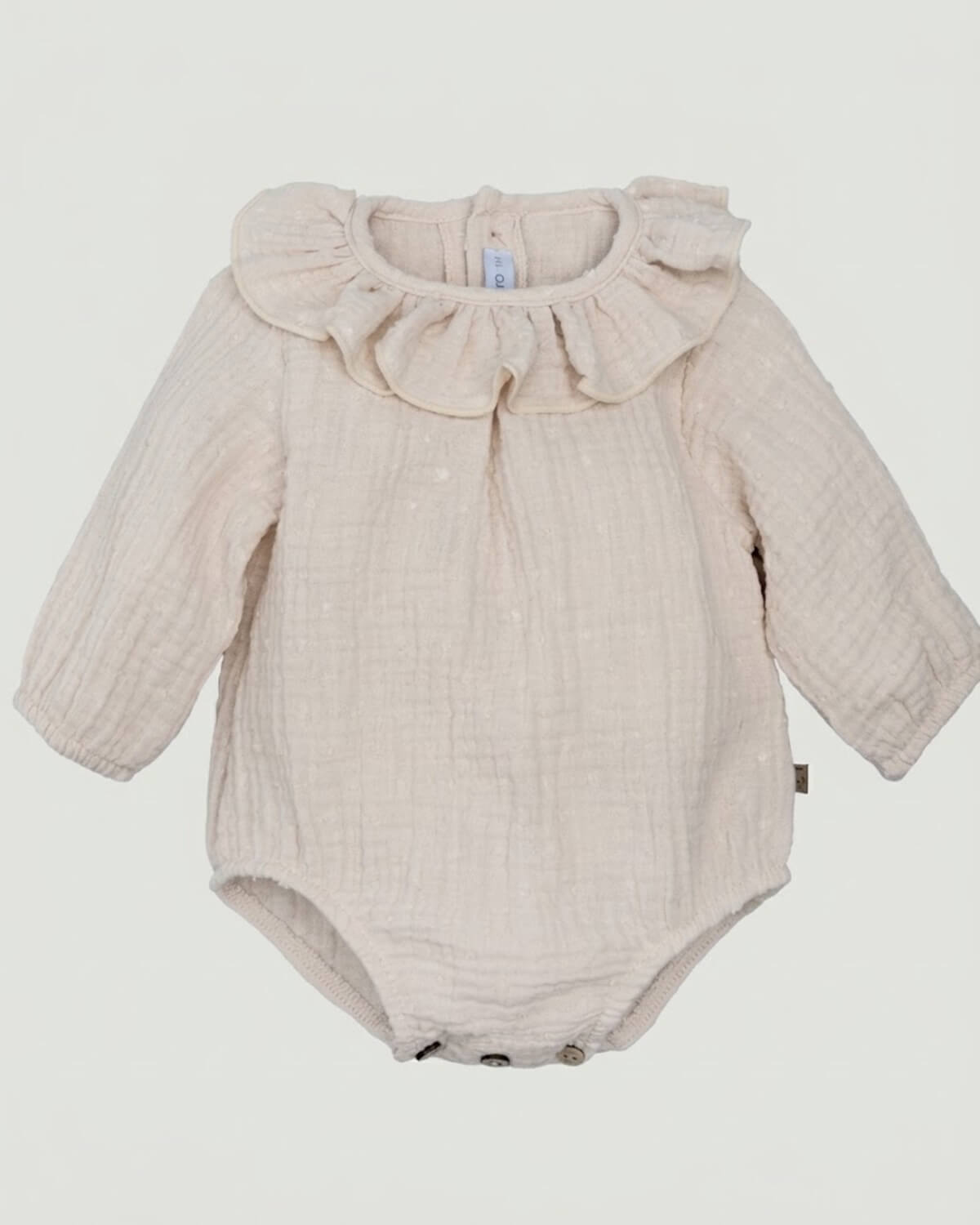 Calamaro traditional Spanish baby romper in cream double gauze plumeti fabric with ruffle collar.