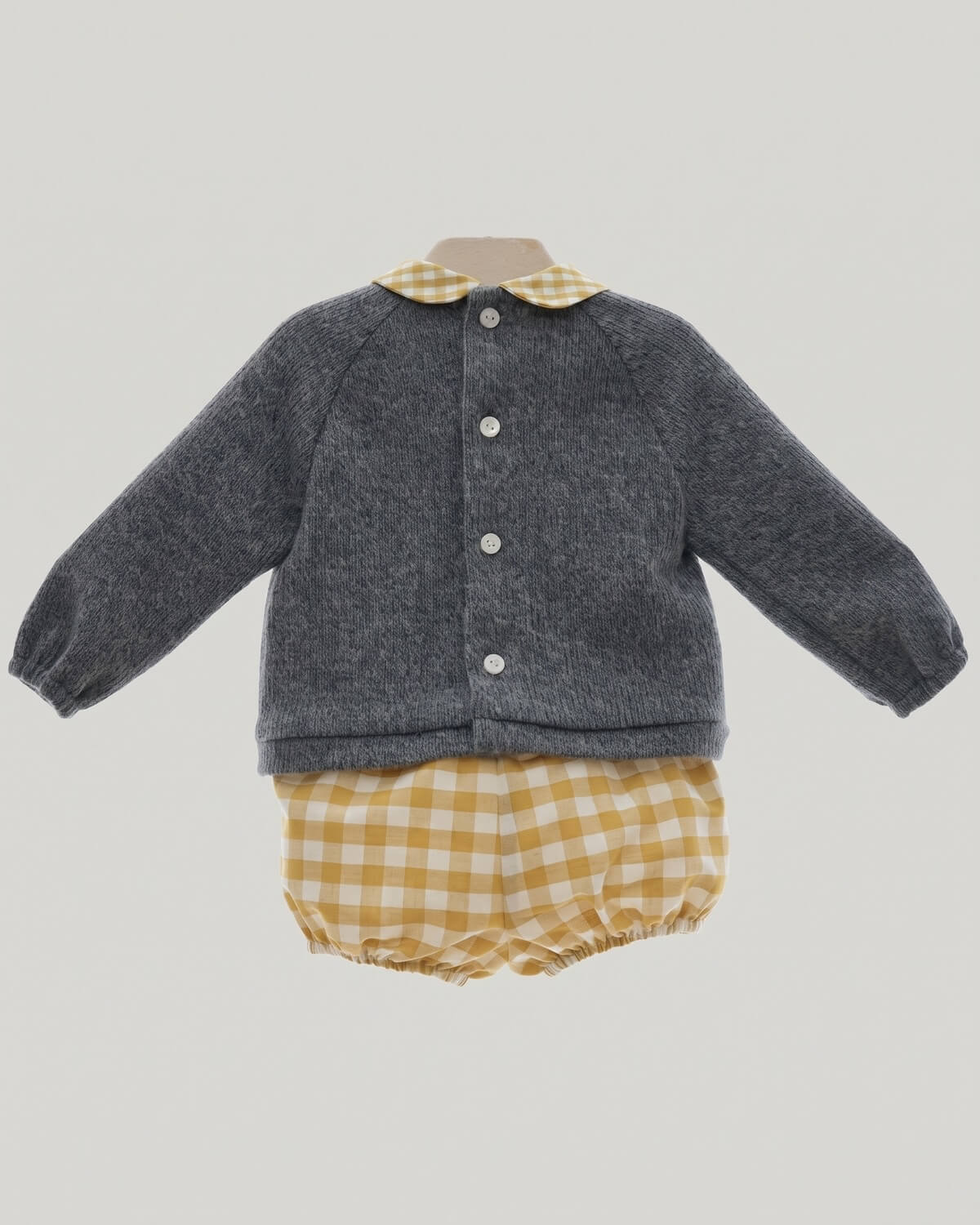 Back view of traditional Spanish baby grey knitted jumper showing button fastening and yellow gingham Peter Pan collar.