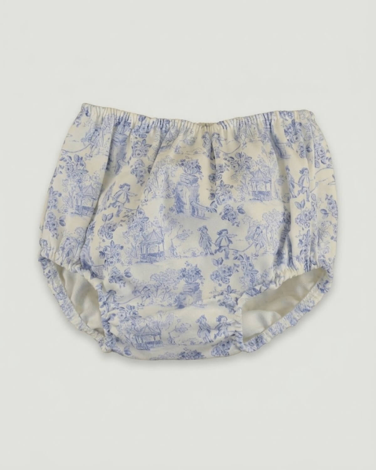 Detail view of traditional Spanish baby bloomers in blue and white toile de Jouy printed cotton fabric.
