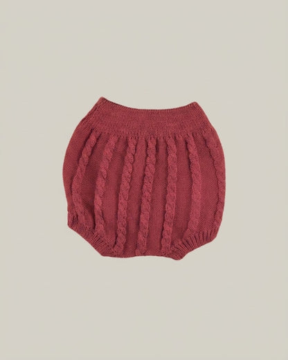Detail view of traditional Spanish baby bloomers in burgundy cable knit.
