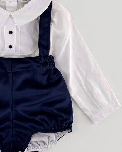 Close-up detail of Peter Pan collar shirt with pleated front and navy blue velvet braces on Spanish baby bloomers.