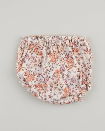 Detail view of traditional Spanish baby bloomers in autumn floral printed cotton fabric with burgundy and terracotta tones.